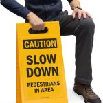 SmartSign - SF-0292-FB-25x12 Caution - Slow Down, Pedestrians In Area Folding Floor Sign By | 25" x 12" Plastic Black on Yellow